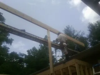 Carpenter setting a ridge beam over a new addition frame — Ice Dam Removal by Roofing Brothers in Battle Ground