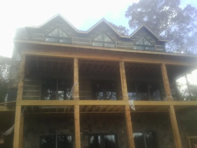 Dormers and porch framing on a large log home under construction — Roof Coating work by our crew in Battle Ground