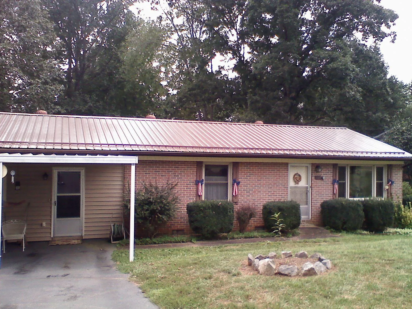 Bronze metal roof and carport on a brick ranch home — Roof Repair work by our crew in Battle Ground